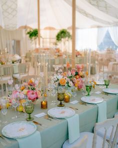 the tables are set with flowers and plates