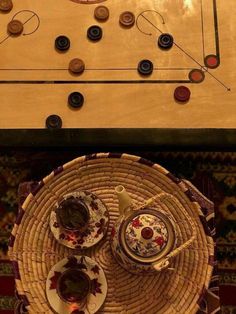 an overhead view of a table with plates and cups on it, next to a game board