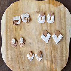 several different shapes and sizes of earrings on a wooden board