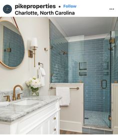 a bathroom with two sinks, a shower and a large mirror on the wall above it