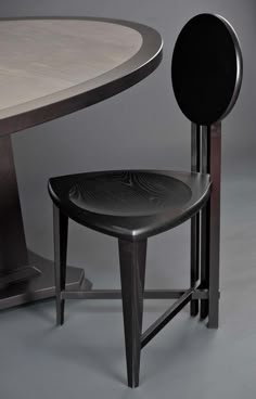 a black chair sitting next to a white table