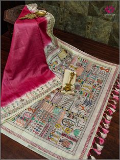 A handpainted tussar saree in dark pink with Madhubani art on the pallu is a stunning piece of art. Tussar silk, known for its rich texture, serves as a beautiful base for the intricate Madhubani motifs. On the pallu, you find the depictions of elephants, fish, peacocks and the geometric patterns- all rendered in the distinctive Madhubani style. The motifs are intricately detailed, with bold outlines and filled with harmonious earthy tones and bright accents. Each element is carefully handcrafte Pink Kalamkari Traditional Wear For Navratri, Pink Chanderi Traditional Wear With Kalamkari Print, Pink Art Silk Kalamkari Traditional Wear, Unstitched Pink Kalamkari Traditional Wear, Pink Unstitched Kalamkari Traditional Wear, Pink Kalamkari Print Dupatta For Diwali, Pink Kalamkari Dupatta For Diwali, Festive Pink Kalamkari Print Dupatta, Festive Pink Kalamkari Dupatta