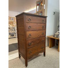 an old wooden chest of drawers in a room with carpeted flooring and furniture