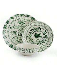 three green and white plates with designs on them, one has a bird in the center