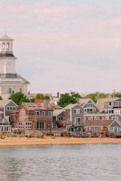 a small town by the water with a clock tower in the backgrounge