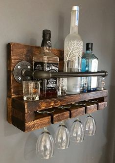 a wooden shelf with wine glasses and liquor bottles on it, hanging from the wall