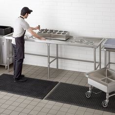 a man standing in front of a metal table