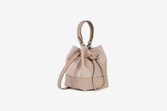 A modern take on the classic bucket bag, our best-selling Osette is your perfect everyday companion. Deceptively spacious, the soft structure is handcrafted in Spain and features an elegant drawstring closure, complete with our signature music bar. This compact yet versatile silhouette can be carried in hand by the leather top-handle, or styled as a crossbody bag with the detachable leather strap - for elegant ease in your everyday. All of our cashmere is consciously created with the highest lev Music Bar, Luxury Designer Handbags, Classic Silhouette, Leather Top, Handbag Accessories, Smooth Leather, Leather Trims, Purse Wallet, Gold Hardware