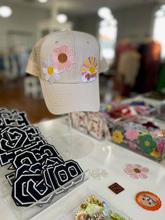 Score a custom hat for $39! The hat color and patches will be a total mystery! We have a variety of hat colors including black, white, red, yellow, orange, blue, green, pink, and more. Our patches could be your initial, athletics, boho, western, flowers, travel, etc. All hats are adult size and will include 3 patches. ALL SALES ARE FINAL. Are you ready for the mystery? Below are some examples of hats made in store. Want to make your own? Visit us in store for the Hat Making Experience! Summer Hats With Logo Patch And Curved Brim, Curved Brim Hats With Logo Patch For Summer, Flat Brim Hats With Logo Patch For Spring, Curved Brim Summer Hats With Logo Patch, Trendy Baseball Cap With Patches And Curved Brim, Retro Trucker Hat With Curved Brim For Spring, White Summer Hats With Logo Patch, Multicolor Curved Bill Baseball Cap For Spring, Retro Curved Brim Trucker Hat For Spring