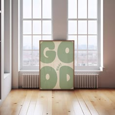 an empty room with two windows and a poster on the floor in front of it