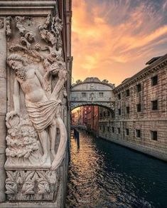 a statue on the side of a building next to a body of water