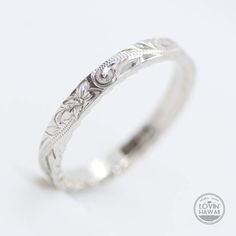 a white gold wedding ring with an intricate design