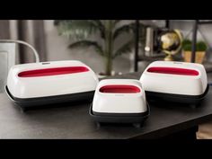 three white and red electronic devices sitting on top of a table