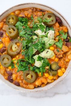 a bowl filled with beans and vegetables on top of a table