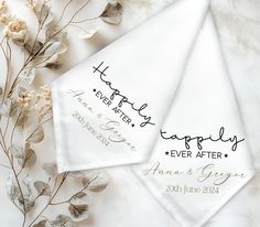 two personalized wedding handkerchiefs sitting on top of a marble table next to flowers