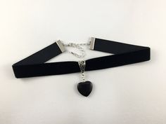 A beautiful black velvet choker featuring a Black Onyx gemstone heart.  Onyx is a strength-giving crystal that provides support during times of mental or physical stress. It aids self confidence and alleviates fears and worries, helping you feel comfortable within yourself and in your surroundings.  The choker measures 12 inches in length and fastens with a lobster clasp. It has a 6cm silver plated extender chain for a perfect fit. Handmade by myself using high quality velvet ribbon and a natural crystal heart. The choker will be packaged in a pretty organza gift bag so it would make a lovely gift. Please visit my shop where I sell a range of handmade, gothic jewellery, including earrings and pendants. Goth Jewellery, Gothic Choker, Jewelry Goth, Gothic Jewellery, Goth Choker, Heart Jewellery, Pentagram Necklace, Goth Necklace, Goth Earrings