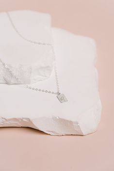 A tiny rectangle tag charm hangs beautifully from our sparkly cable chain.Classic, minimalist & dainty. Created in 14k gold filled or sterling silver. Hand stamped with 1 initial OR 1 symbol per charm. We can only stamp on the front of the charm. The tag charm measures 10mm x 6mm. Add as many tags as you need. Add additional tags as your family grows! Spring ring clasp.Handcrafted in our San Clemente studio. Need more than 3 tags, you can add them right above the add to cart button. Dainty Sterling Silver Initial Necklace With Cable Chain, Sterling Silver Initial Necklace With Cable Chain, Minimalist Sterling Silver Initial Necklace, Minimalist Sterling Silver Initial Necklace With Charms, Dainty Sterling Silver Charm Necklace With Square Pendant, Dainty Sterling Silver Charm Necklace With Rectangular Pendant, Silver Minimalist Initial Necklace With Square Pendant, Silver Dainty Initial Necklace With Cable Chain, Sterling Silver Charm Necklace With Square Pendant