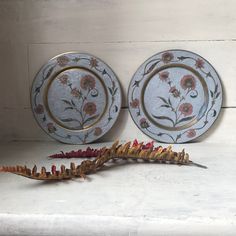 Here is a beautiful set of 2 Vintage Enamelled Brass Wall Plates with a lovely floral engraving.  These round hanging wall plates have a gorgeous cloisonné floral pattern with coral or salmon coloured flowers on a leafy stem in the centre of the plate and an outer border of a garland of the same flower, leaves and stems all on a silver/grey enamelled background - so pretty.  Add a lovely touch to your Boho Decor with this fabulous set. In good vintage condition with some surface marks, patina on Display Plates, Modern Rustic Decor, Basket Wall Decor, Organic Decor, Leaf Plates, Hanging Plates, Boho Wall Hanging, Mural Floral, Plate Display