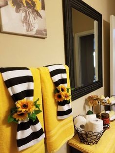 towels with sunflowers on them are sitting next to each other in front of a mirror