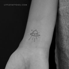 a small saturn tattoo on the wrist