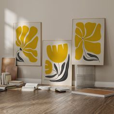 three yellow and black flowers are on the wall above a wooden floor in an office