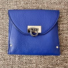 This Salvatore Ferragamo Wallet Is A Triumph Of Style And Design. Finished In Textured Bright Blue Leather, This Wallet Folds Out To Reveal Many Card Pockets And Long Pockets For Cash. This Is Secured By A Silver-Tone Twist Lock. The Back Pocket Opens To An Accordion Fold Compartment. Exterior Material Leather Interior Material Nylon Length 5” Width 0.39” Height 4” Hardware Silver Tone Tri Fold Wallet, Ferragamo Wallet, Accordion Fold, Fold Wallet, Trifold Wallet, Tri Fold, Leather Interior, Blue Leather, Bright Blue