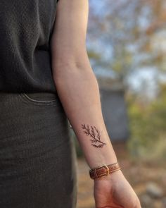 a woman's arm with a small tattoo on it