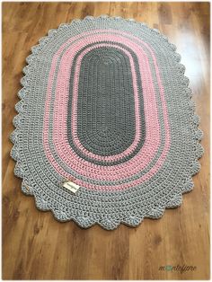 a crocheted rug on the floor with a pink and gray circle around it