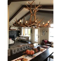 an antler chandelier hanging from the ceiling in a living room