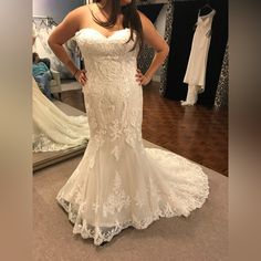 a woman standing in front of a mirror wearing a wedding dress