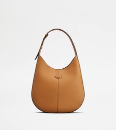 The timeless elegance of the Di Bag style is declined in a hobo version with sober and essential lines. Crafted in fine natural grain calfskin leather, it comes with an adjustable shoulder handle and the characteristic Tod's logo stamped on the front. Complemented by a removable internal pouch, it accompanies your everyday outfits with class and femininity. Classic Tan Calf Leather Bag, Classic Tan Shoulder Bag With Leather Lining, Classic Tan Calf Leather Shoulder Bag, Brown Calf Leather Hobo Bag For Business, Business Brown Calf Leather Hobo Bag, Timeless Hobo Bag With Smooth Grain, Classic Calf Leather Hobo Shoulder Bag, Timeless Leather Hobo Bag For Formal Occasions, Timeless Smooth Grain Hobo Bag