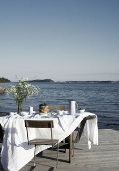 the table is set on the dock by the water