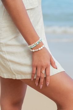 Flanked with natural white fresh water pearls pikake shell flowers, this unique bracelet evokes visions of Hawaii's white sands and soothing shores. Stack this gold bracelet with other beaded beauties and you'll be ready for your tropical escape.✦ DETAILS ✦✧ Name: Momilani (moh-mee-LAH-nee) - pearl from heaven.✧ Adjustable from 6.5"- 8".✧ Hand carved mother of pearl pikake.✧ Natural Freshwater Pearls.✧ 14kt Gold Filled accents with lobster clasp.✧ All Ke Aloha Jewelry pieces come packaged though White Beaded Pearl Bracelet For Vacation, White Beaded Pearl Bracelet For Beach, Bohemian White Pearl Bracelet For Beach, Elegant Hand-strung Jewelry For Beach, Elegant Hand-strung Beach Jewelry, White Ocean-inspired Jewelry With Round Beads, Ocean-inspired White Round Bead Jewelry, Bohemian White Pearl Beaded Bracelets, Ocean-inspired White Round Beaded Jewelry