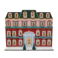 a large pink and blue doll house with christmas decorations on the front door, windows and trees