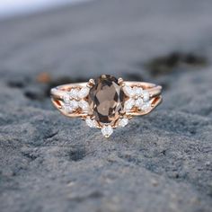 a brown and white diamond ring sitting on top of a rock