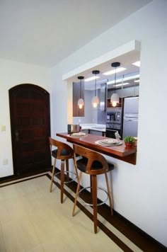 a kitchen with two bar stools next to an open door and a counter top