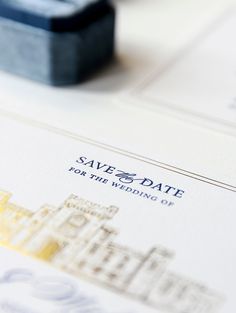 save the date cards are sitting on top of a white table with blue and yellow ink