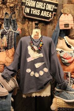 an assortment of sweaters and hats are on display in a shop window with the words farm girls only in this area