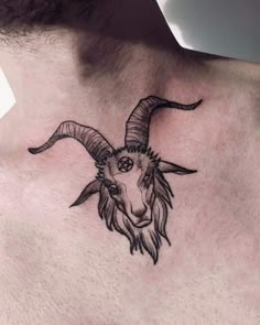 a man with a goat head tattoo on his chest