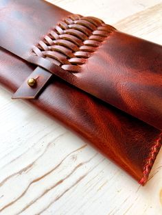 a brown leather wallet sitting on top of a wooden table