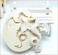 a white dragon statue sitting on top of a wooden bench