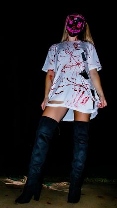 a woman wearing knee high boots and a t - shirt with blood all over it