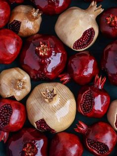 many pomegranates are arranged in rows on a black surface with red and yellow accents