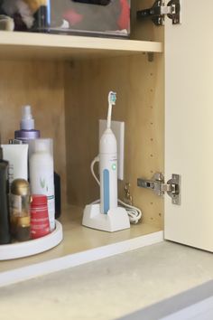 an electric toothbrush and other personal care items in a cabinet