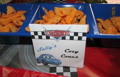 cheetos chips are sitting in blue trays on a table with cars signs