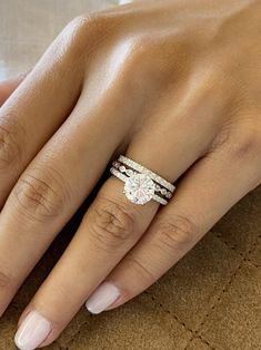 a woman's hand with two engagement rings on her left and the middle finger