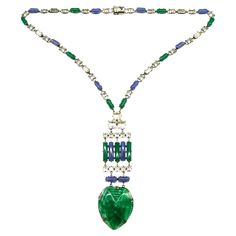 An outstanding Art Deco pendant necklace in highly characteristic colour and design. It is composed of blue and green chalcedony glass rounded baguettes throughout, highlighted with clear cut paste rectangular and square faceted stones. The striking pendant is made of moulded marbled green glass, in a stylised 'heart' design, with moulded patterns to emphasise the decoration. The necklace meets at the back, with a secure push clasp. The necklace is made from silvered metal and is either of Frenc Modern Green Necklace For Formal Occasions, Modern Glass Necklaces For Formal Events, Modern Glass Necklaces For Formal Occasions, Formal Glass Pendant Necklaces, Art Deco Blue Pendant Necklace, Formal Glass Pendant Necklace, Glass Pendant Necklace For Formal Occasions, Glass Pendant Necklaces For Formal Events, Art Deco Pendant Necklace