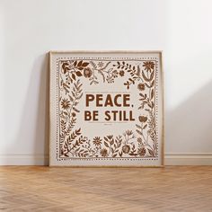 a wooden sign that says peace be still on the wall next to a hardwood floor