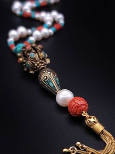 Description and Details  Discover the beautiful Tibetan jewelry masterpiece that represents a blend of traditional and modern elements in this One-of-a-kind Deluxe long necklace!  Freshwater Pearls, Coral, and Turquoise are designed to enhance the beauty of the handmade Tibetan pendant featured in the necklace.  One-of-a-kind  Item: E 450 Freshwater Pearl  Turquoise  Tibetan Silver, Turquoise  Carved Copal Tassel: Vermeil  Clasp: Vermeil  Approx. 29" Silk hand-knotted Elegant Turquoise Jewelry For Meditation, Luxury Handmade Beaded Necklace As Gift, Luxury Handmade Beaded Necklace For Gift, Luxury Gemstone Pearl Necklace, Elegant Hand-strung Lariat Necklace, Elegant Necklaces With Round Beads For Rituals, Elegant Round Bead Necklaces For Rituals, Elegant Multicolor Hand-strung Necklaces, Elegant Multicolor Hand-strung Necklace