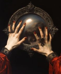 two hands are holding up a mirror to show the reflection of a woman's face